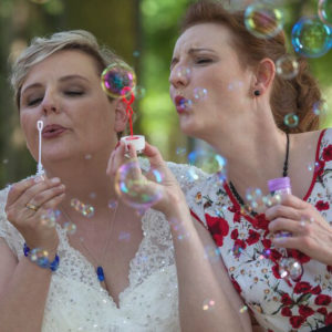 Braut mit blauem Glasschmuck, Frau mit Mohnblumen Kleid und Glasperlenschmuck, Seifenblasen, Hochzeit, Sommer