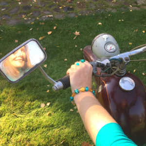 Künstlerin mit braunem Glasperlenarmband auf Moped, Geschenkschachtel, Spiegel, SR2