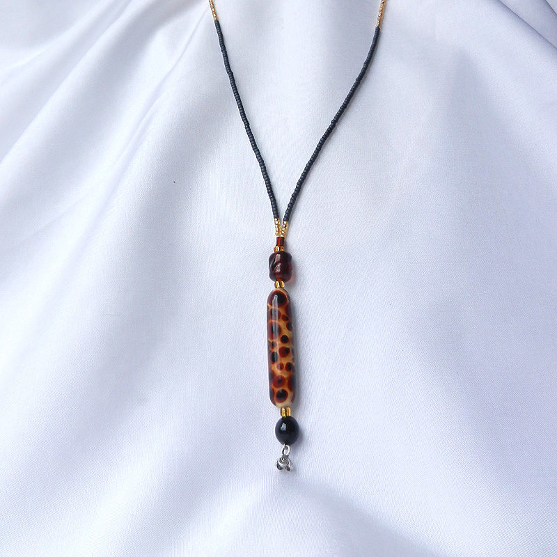 Lange Halskette mit langer Glasperle im Leo-Muster. Handgefertigtes Unikat von schmuckes Glas