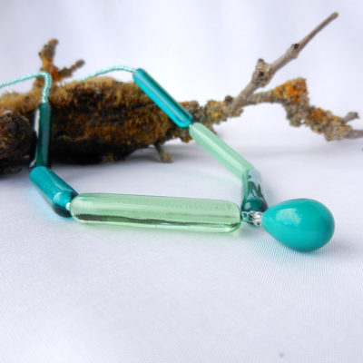 Glasperlenkette in grün, gerade wlzenförmige Glasperlen in unterschiedlichen Grüntönen mit Tropfen Anhänger, lange Perlenkette von schmuckes Glas
